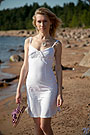 Model Mariana in white dress walking on the empty beach.